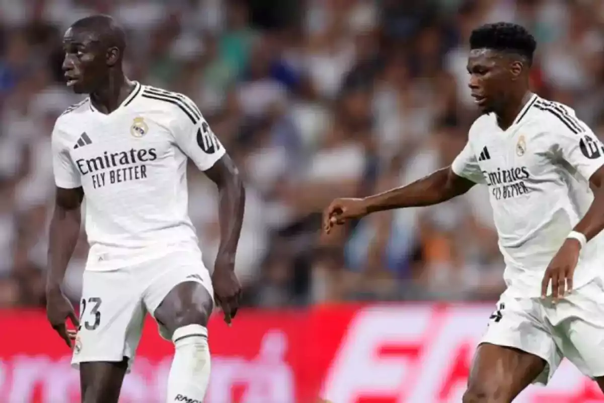 Dos jugadores de fútbol del Real Madrid en el campo durante un partido. Dos jugadores de fútbol del Real Madrid en el campo durante un partido.