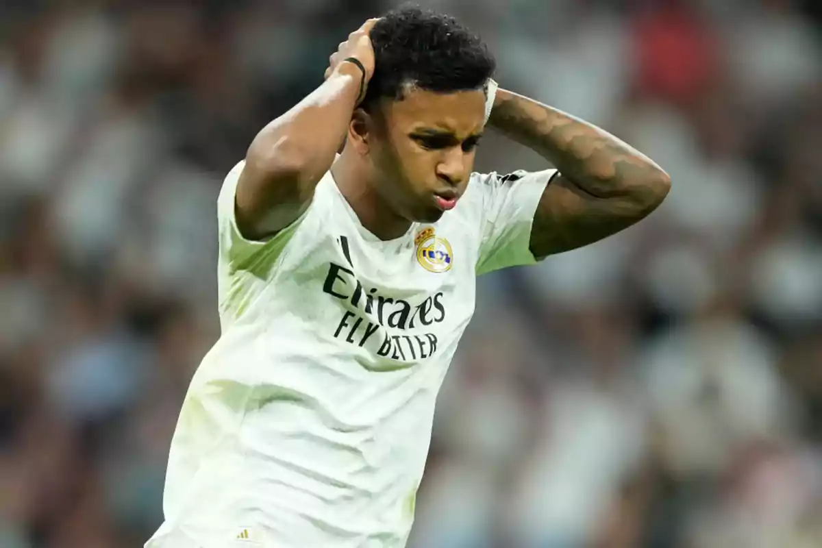Un jugador de fútbol con expresión de frustración se lleva las manos a la cabeza durante un partido. Un jugador de fútbol con expresión de frustración se lleva las manos a la cabeza durante un partido.