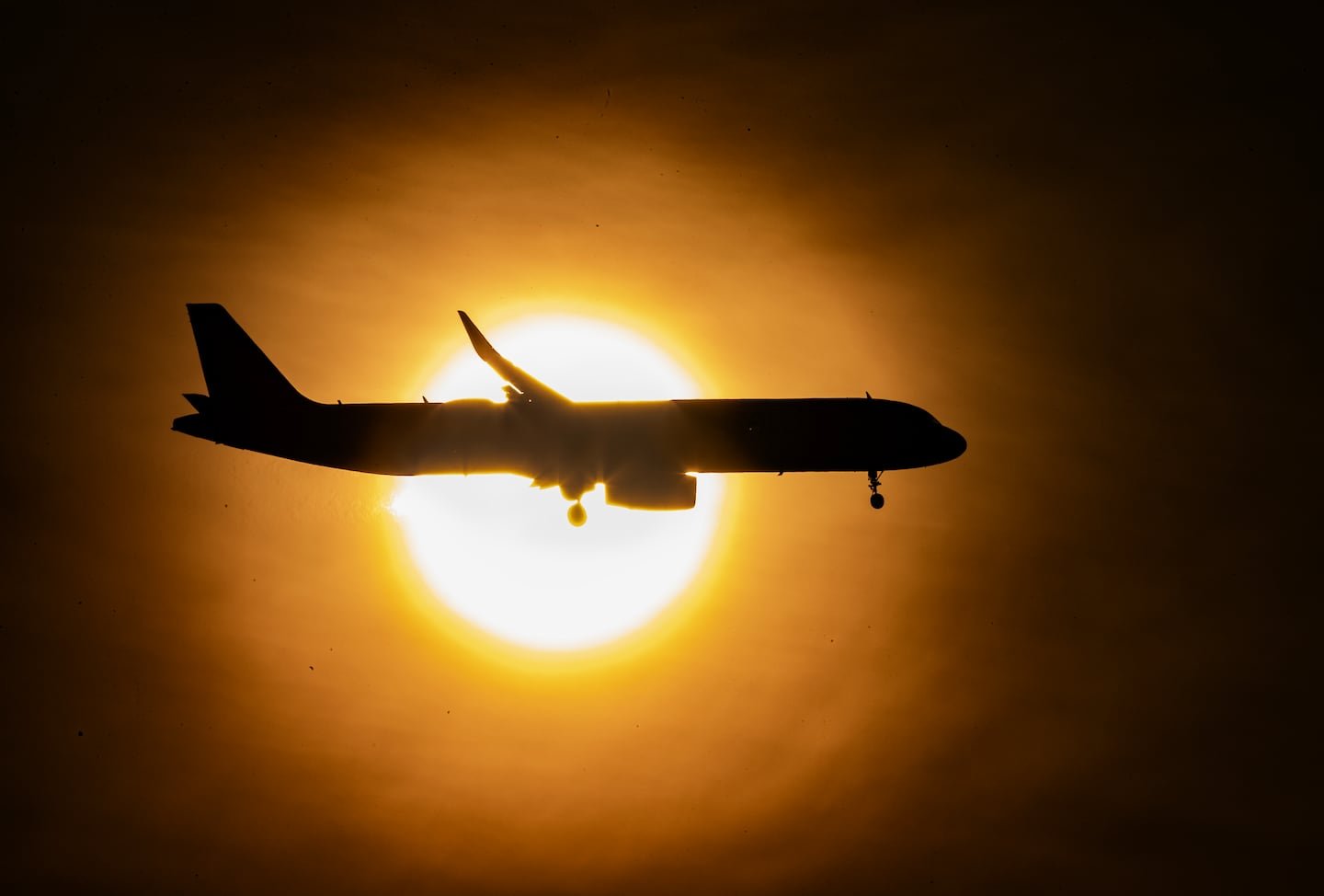 A flight prepared to land at Logan Airport under hazy sunlight accentuated by Canadian wildfires on June 8.
