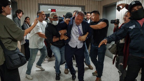 The incident's video, which was shared on X, shows Lander outside a courtroom as masked police officers approach him.(AP)
