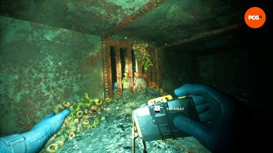 still-wakes-the-deep-dlc-review-camera Still Wakes the Deep DLC review: Mhairi approaches a corpse wedged in a vent, her camera raised to document these human remains.