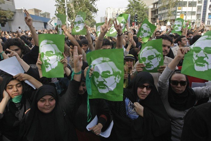 Iranian opposition demonstrators carry portraits of defeated reformist presidential candidate Mir Hossein Mousavi, in Tehran