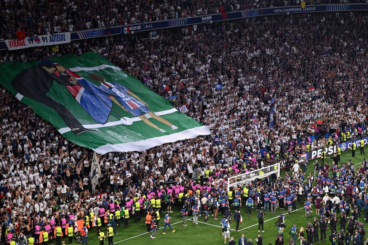 Paris Saint-Germain fans display a banner in the tribunes depicting Paris Saint-Germain’s Spanish head coach, Luis Enrique, planting a flag for his late daughter Xana after the UEFA Champions League final football match between Paris Saint-Germain (PSG) and Inter Milan in Munich, southern Germany, on May 31, 2025. 